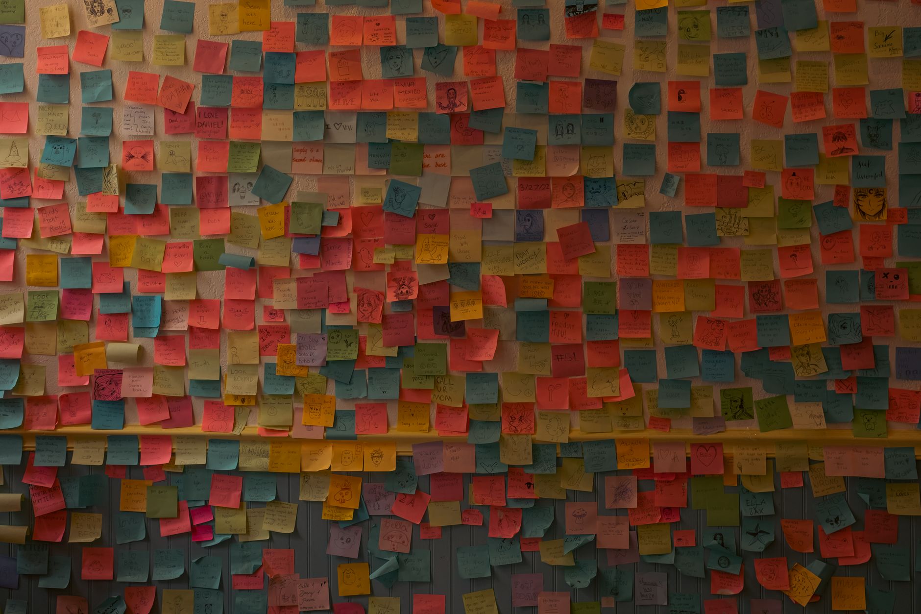 Vibrant collection of sticky notes organized on an indoor wall.